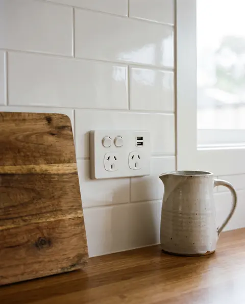 New white Australian double power point with USB charging on a tiled kitchen splashback